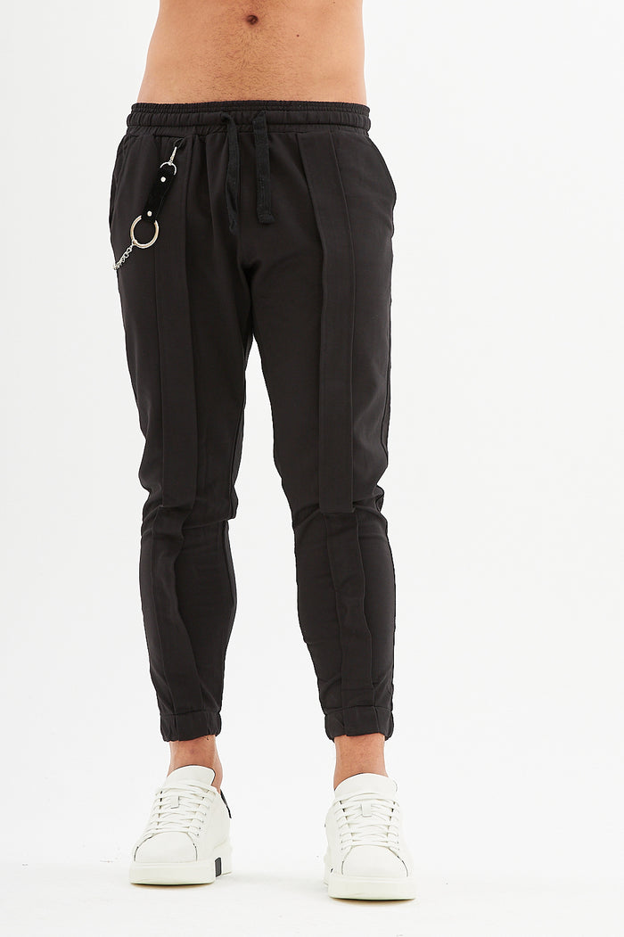 Men's James black denim streetwear pants with drawstring waist, silver chain accessory, and slim-fit urban design.