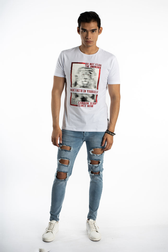 Model wearing Kase Blue Washed Denim Jeans with heavy knee distressing and a Carbon graphic t-shirt.