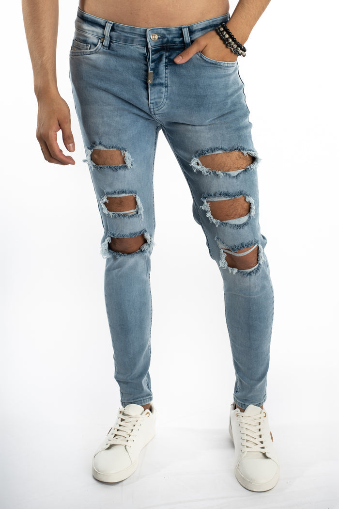 Kase Blue Washed Denim Jeans for men featuring a slim fit and heavy distressed ripped knees, shown on model with sneakers.
