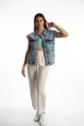 Model wearing Kinley white wide-leg utility pants with drawstring waist and a light-wash denim vest in a streetwear style.