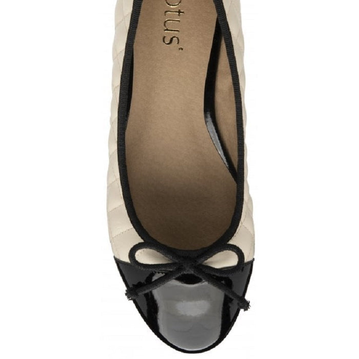 Women’s cream pumps with black patent toe cap and bow tie, interior close-up