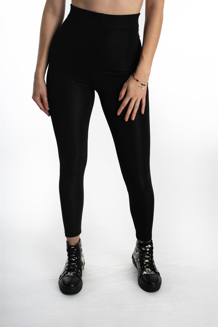 Model wearing Maci high-waisted black leggings in Carbon with high-top sneakers, showing the sculpted athleisure fit.