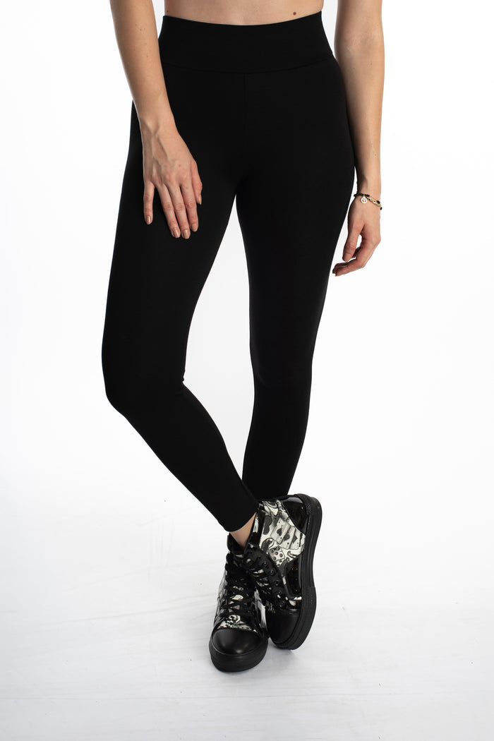 Close-up of Maci high-waisted black leggings in Carbon with a wide sculpting waistband and graphic high-top sneakers.