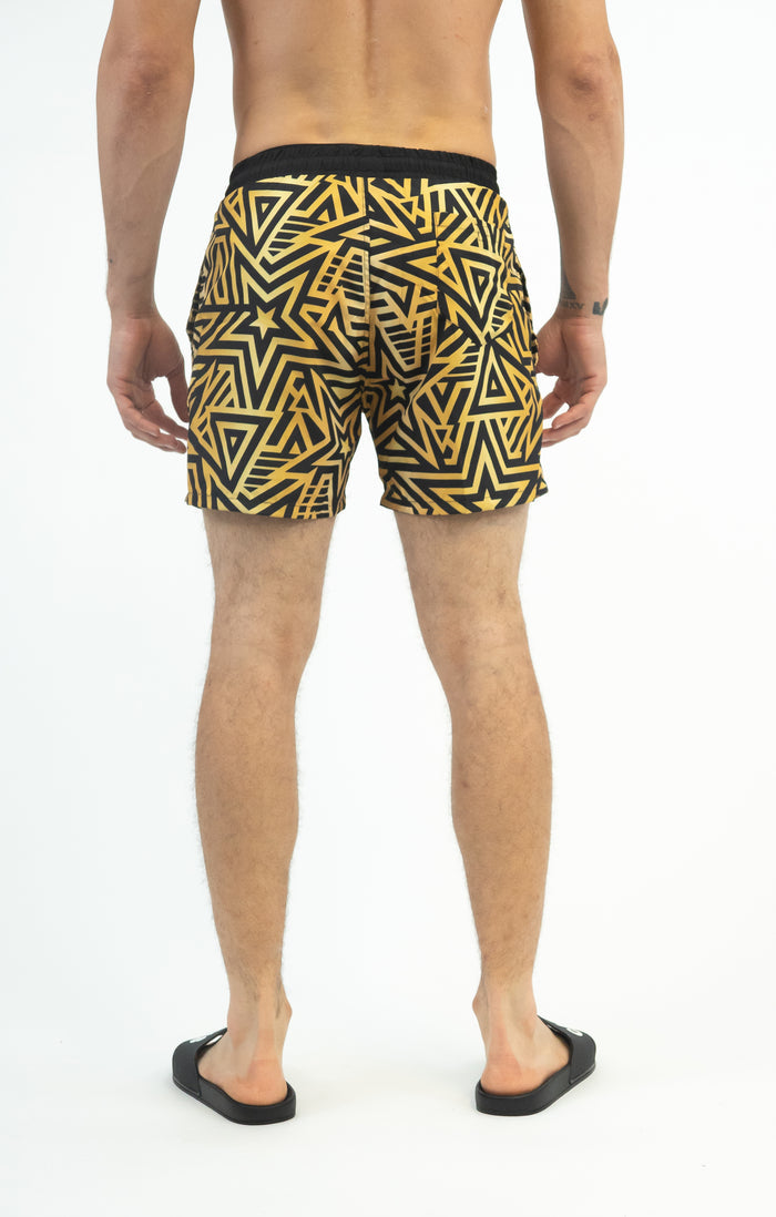 Rear view of Men's Quick-Dry Swim Trunks in Carbon with black and gold geometric star print and elastic waistband.