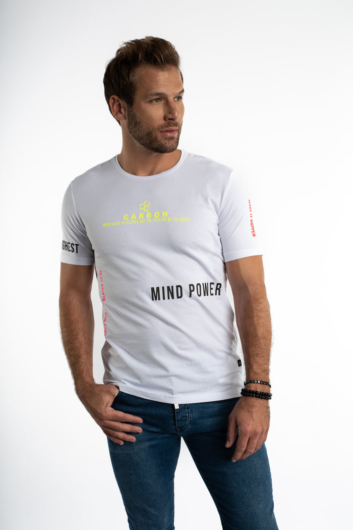 Man in white Mind Power streetwear graphic tee with neon yellow Carbon text and blue denim jeans.