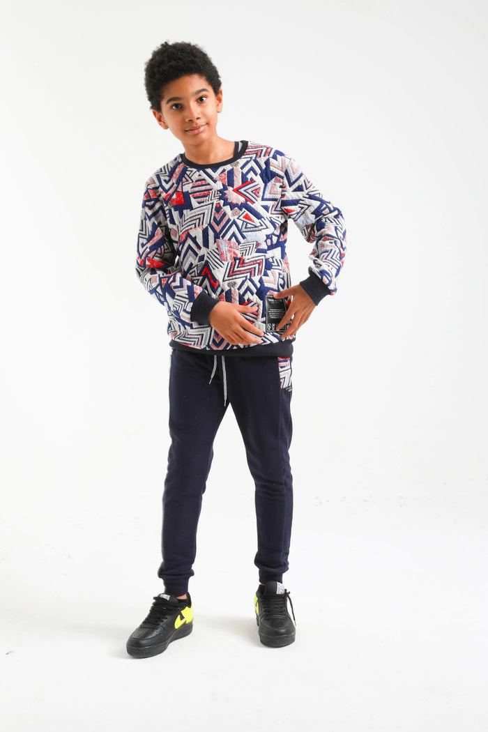 Boy wearing Nanica geometric sweatshirt and navy jogger set, front view