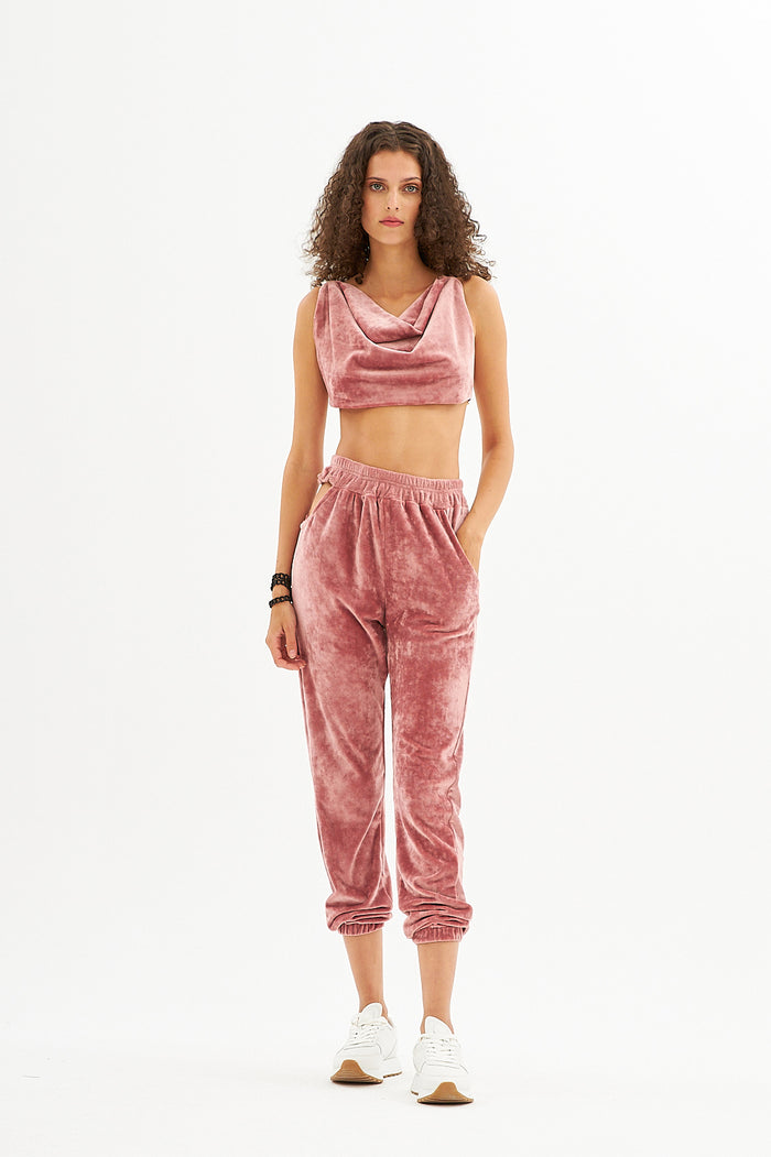 Model in pink velvet Natalie two-piece set featuring a cowl neck crop top and matching joggers with streetwear vibe.