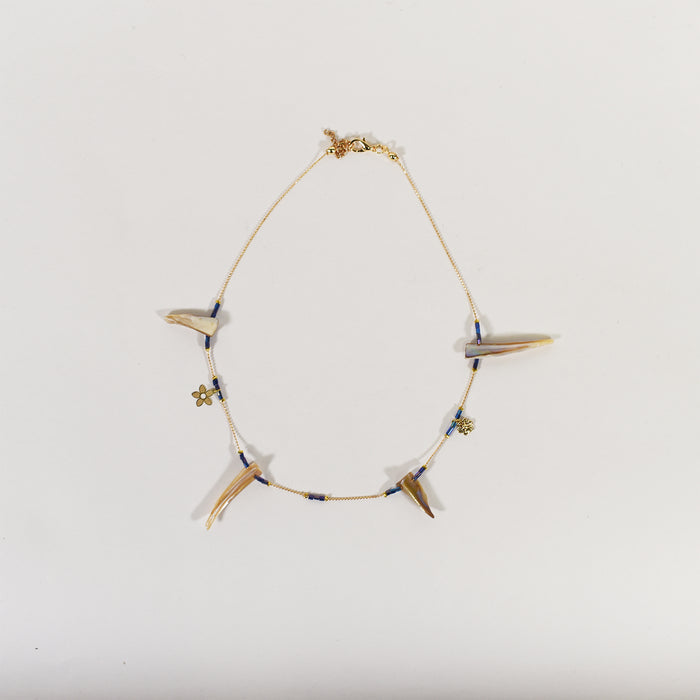 Minimalist gold chain necklace featuring iridescent shell charms, small blue beads, and gold flower accents.