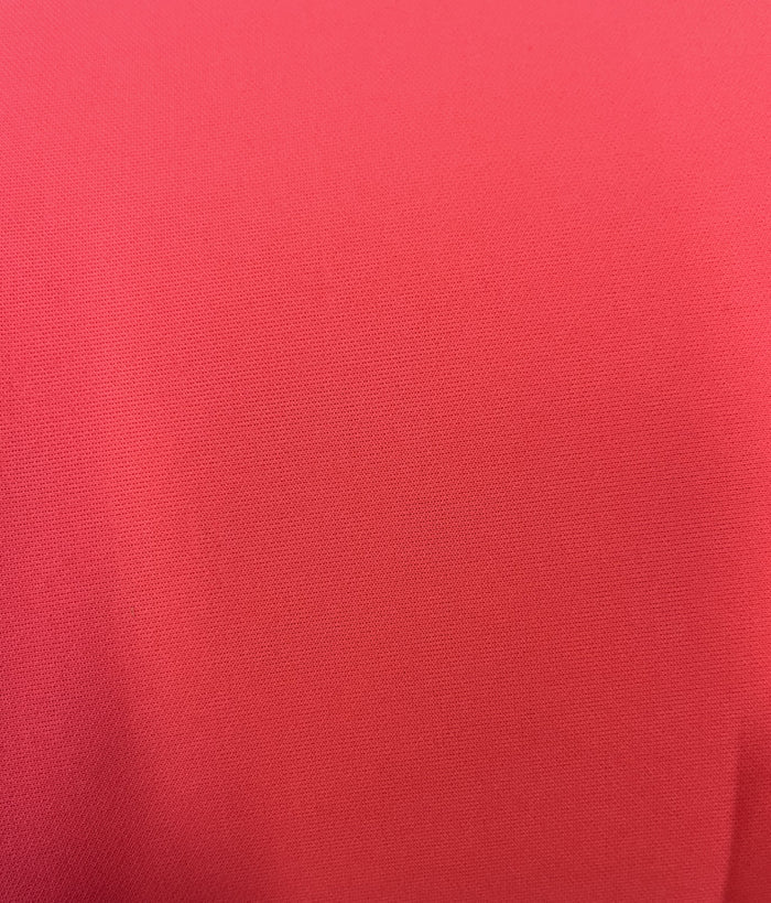 A close-up image of neon pink neoprene scuba knit fabric.