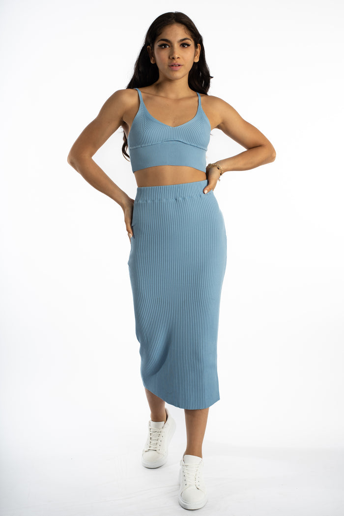 Model in light blue Nia Ribbed Knit Midi Skirt and matching crop top with white sneakers for a trendy summer look.