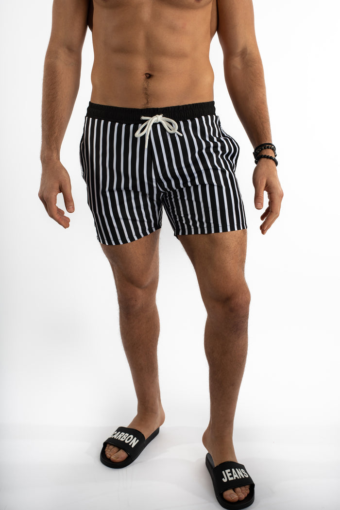 Men's Niko black and white vertical striped swim trunks with drawstring and elastic waistband by Carbon Jeans.