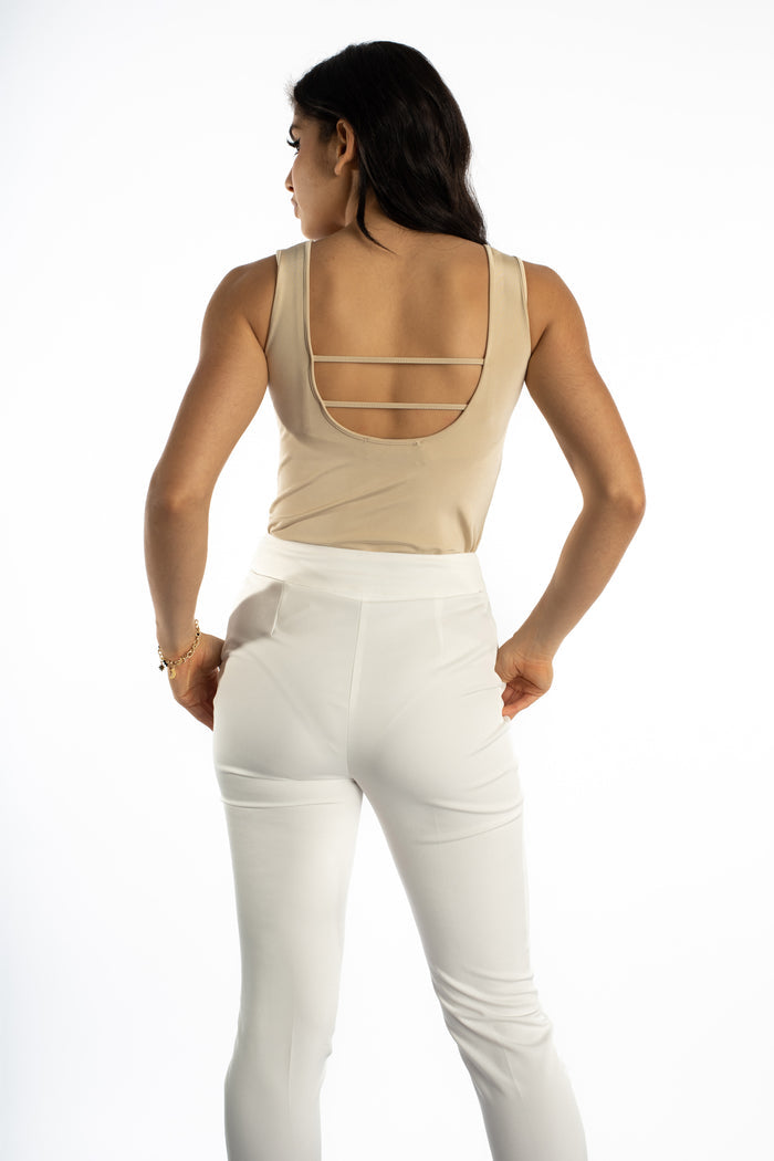Back view of the Noa ribbed sleeveless bodysuit in beige featuring a scoop back with strappy details and white trousers.