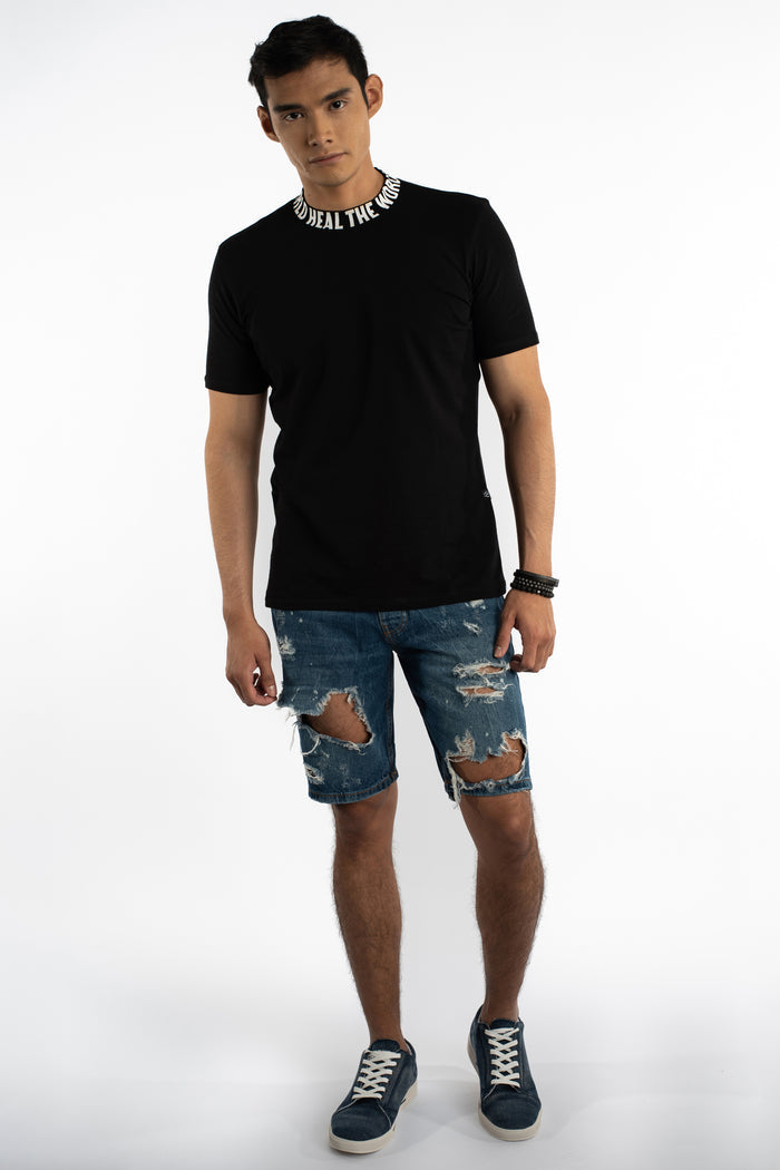 Model in Otto blue distressed denim shorts with heavy ripping and slim fit streetwear style for men.