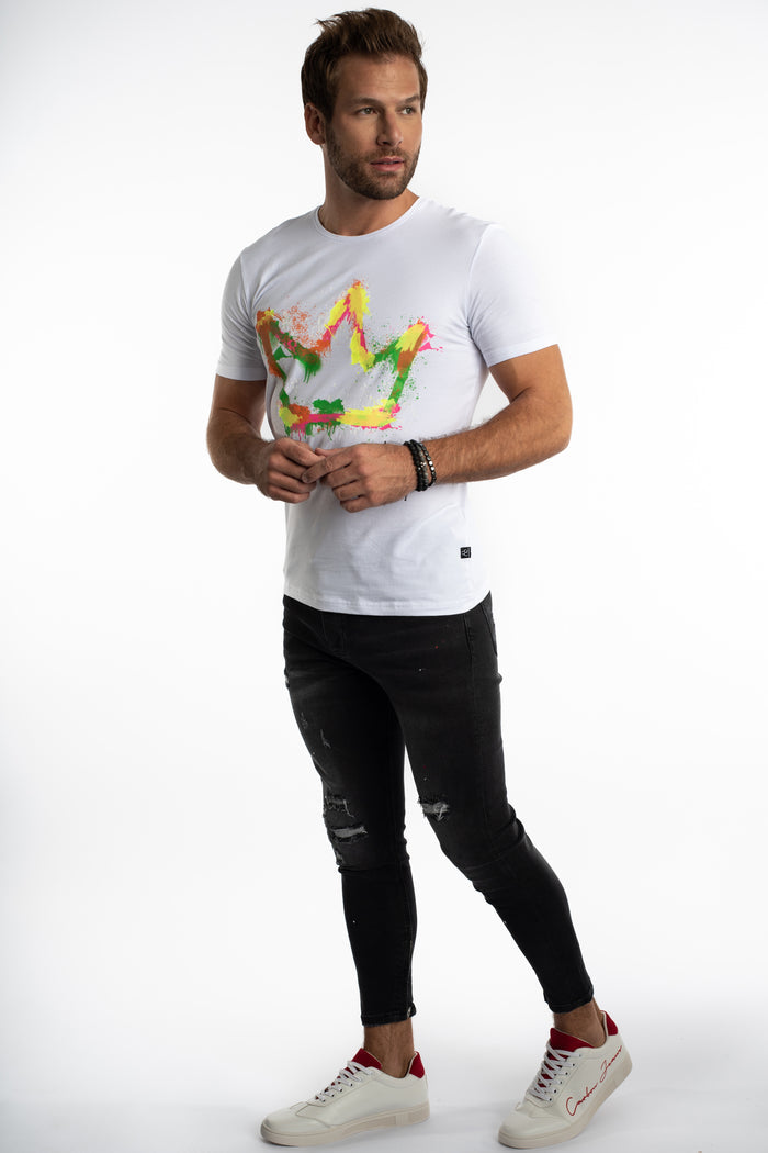 Model wearing a white Painted King Graphic Streetwear Tee with a colorful crown print and distressed black jeans.