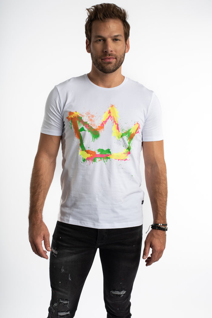 Model wearing a white Painted King graphic streetwear tee with a colorful paint-splatter crown and distressed black jeans.