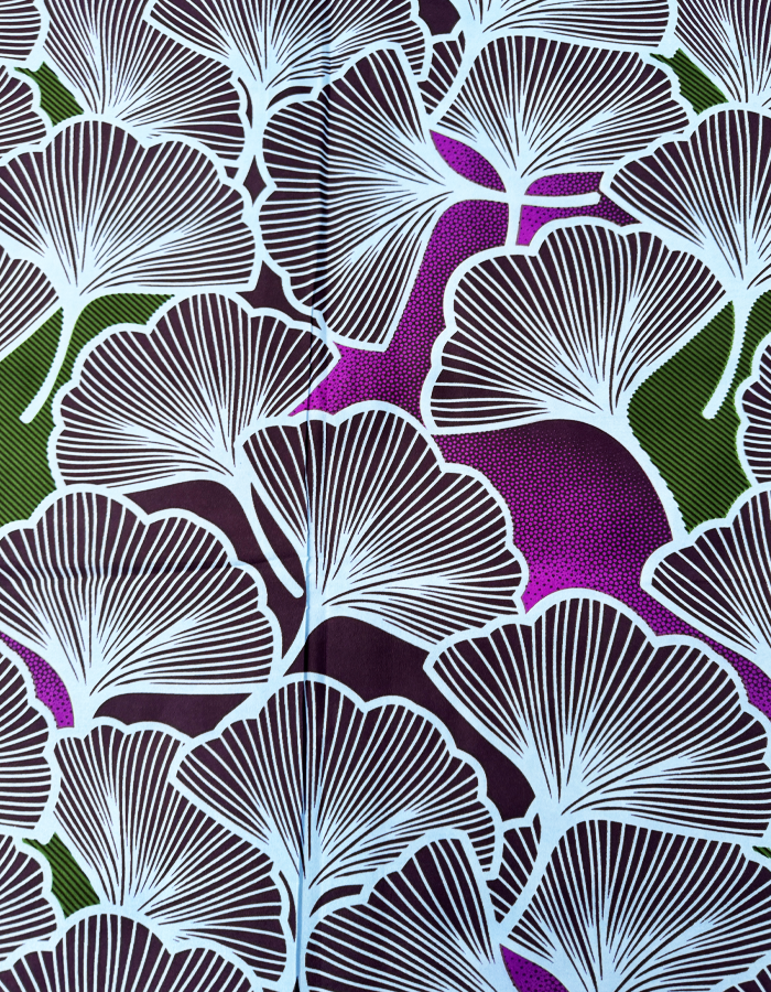 African Patterned fabric with white leaves on a purple and green background