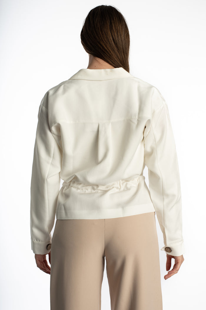 Back view of the Rhea White Denim Jacket in a streetwear style featuring a cinched waist and drop shoulder seams.
