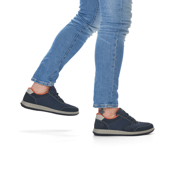 Men's dark blue sneakers with orange insides, worn with blue jeans