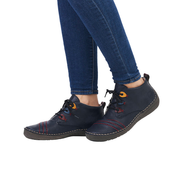 Dark blue lace-up sneakers with orange and red accents worn with blue jeans