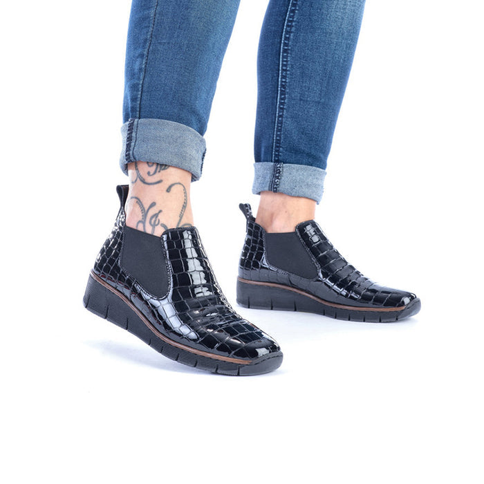 Pair of black slip-on ankle boots with crocodile finish and cushioned wedge sole