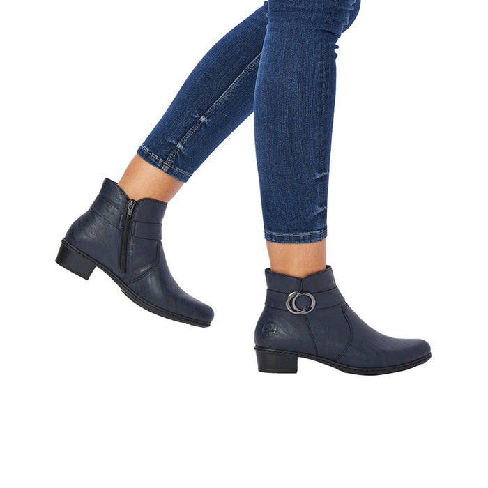 Blue ankle boots with metal-ring strap on block heels, worn with jeans