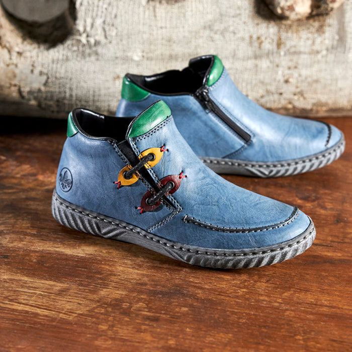 Pair of women’s blue lace-up slip-on boots with green ankle accents and textured sole