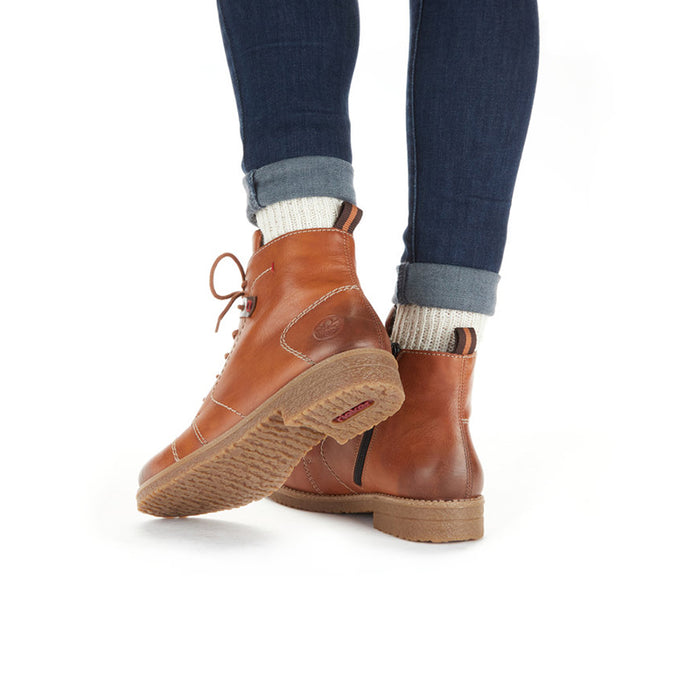 Brown lace-up ankle boots on a model with denim jeans and sock cuff