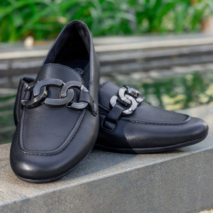 Black leather loafer shoes with metal buckle strap, front close-up