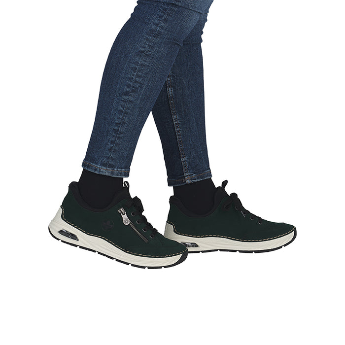 Women's dark green slip-on loafers worn with blue jeans and a white sole