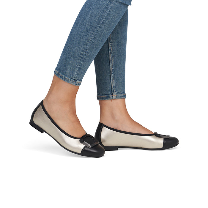 Women’s flat pumps on model: cream upper with black trim and buckle strap