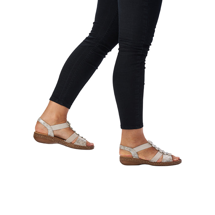 Women's silver sandals worn with dark pants; two strap buckles and platform sole