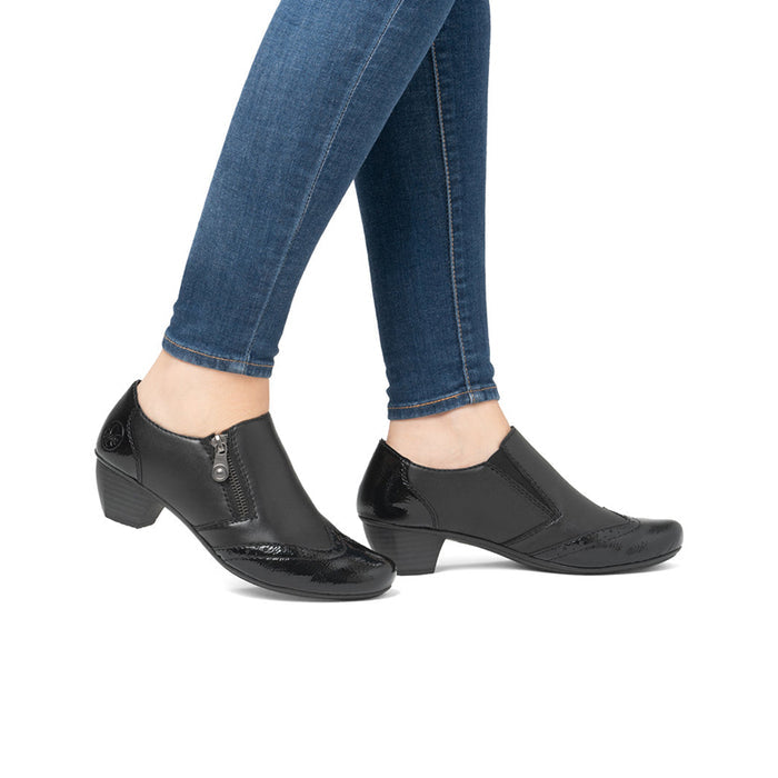 Women's black zip casual shoes with patent toe and block heel worn with jeans
