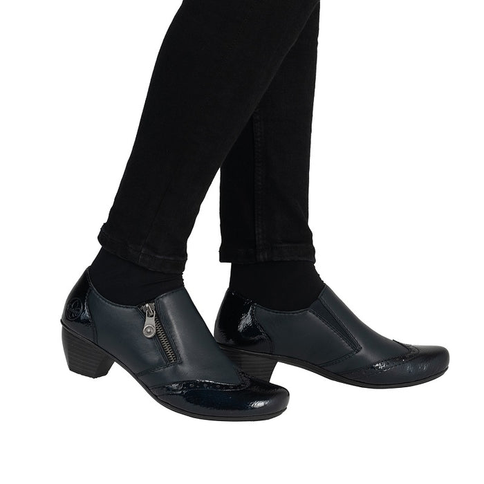 Women's black zip casual shoes with patent toe and block heel worn with trousers