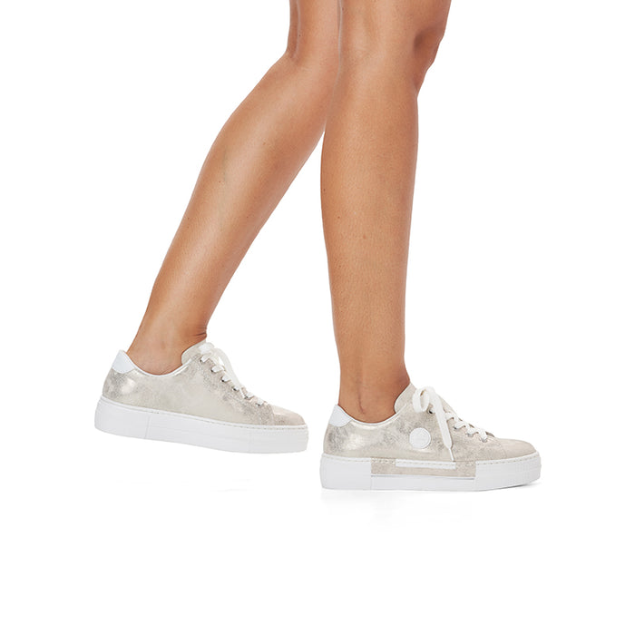Rieker women's silver sneakers on model feet, low-profile white sole