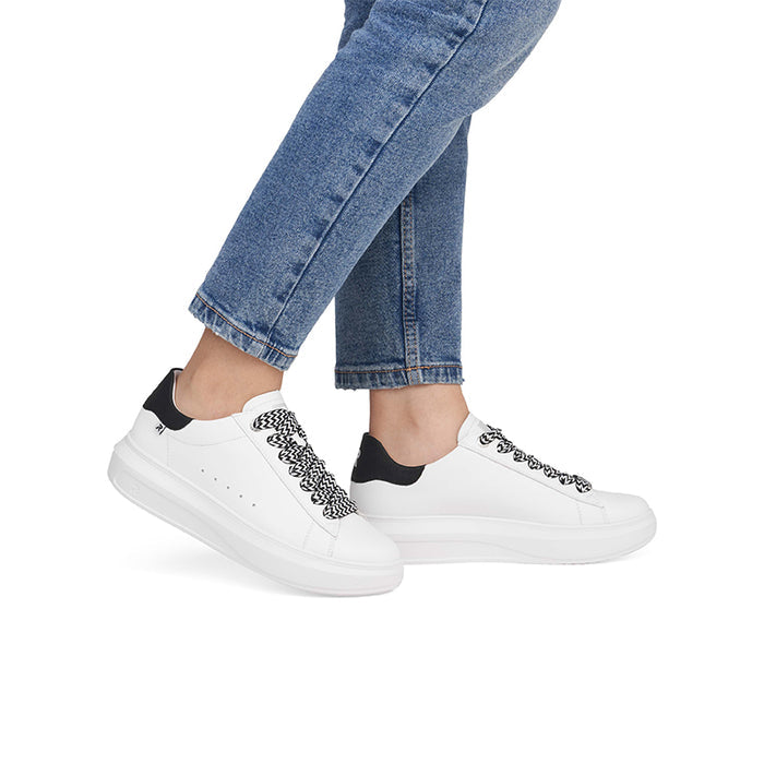 White lace-up sneakers with black patterned laces and black heel tab on jeans