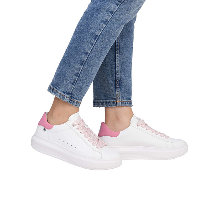 White lace-up sneakers with pink laces and pink heel tab on jeans