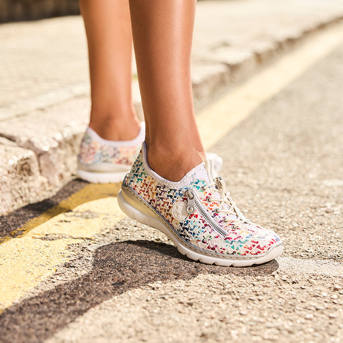 Rieker women's multicolor sneakers on feet, patterned knit upper and white sole