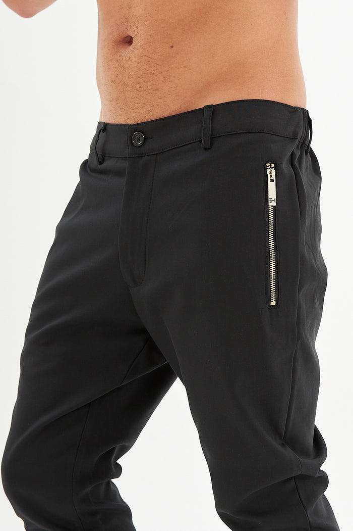 Close-up of Ronald black slim fit pants for men featuring urban streetwear style with a silver vertical side zipper pocket.