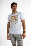 Man wearing a white Social Graphic Streetwear Tee with colorful gradient text and distressed grey denim shorts.