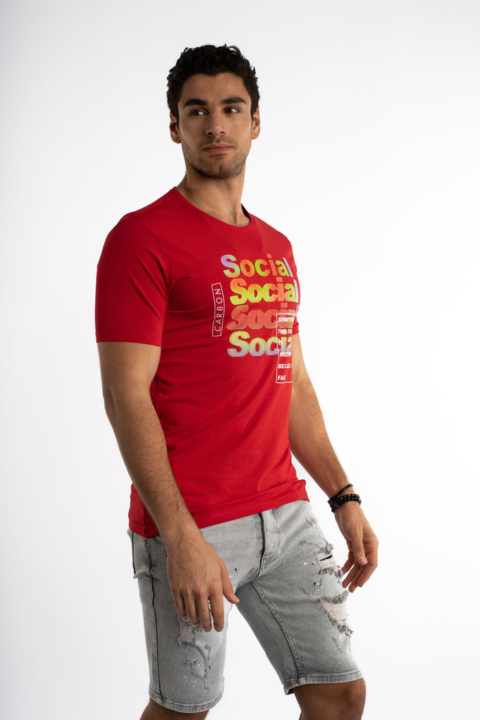 Man in a red Social Graphic Streetwear Tee with a gradient logo and distressed denim shorts, ideal for an urban OOTD.