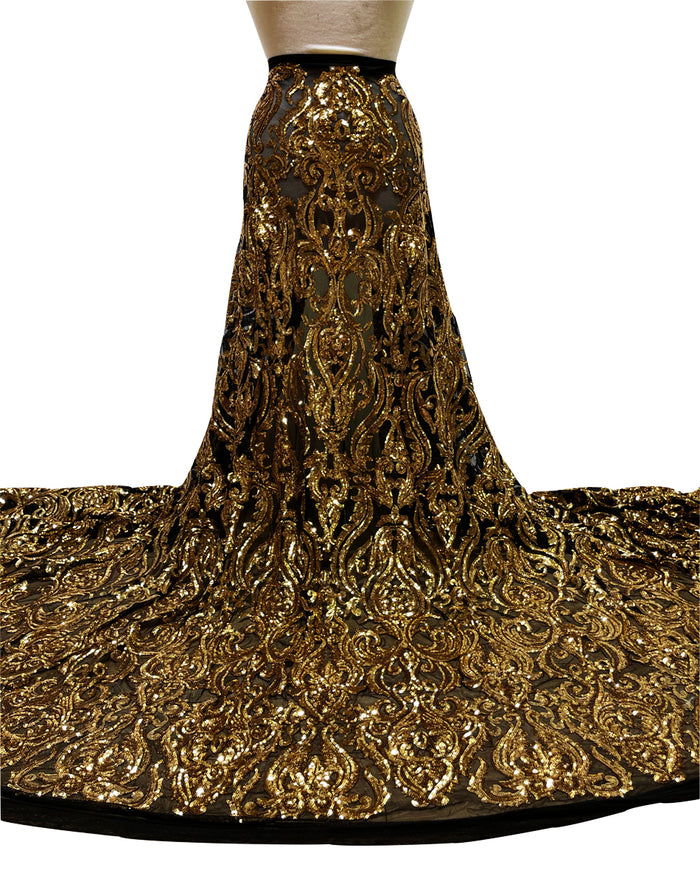 A swatch of stretch gold bridal sequins on black stretch mesh fabric, displaying the texture and shine of the material.