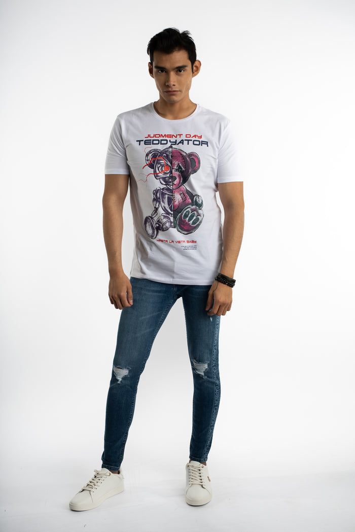 Men's white Teddyator cyborg bear graphic streetwear t-shirt styled with distressed blue jeans and white sneakers.
