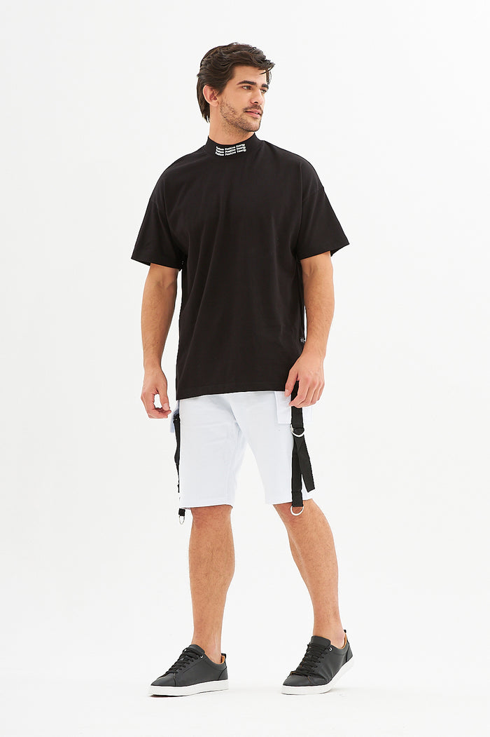 Model in Tommy White Denim Shorts with black straps, paired with a black streetwear t-shirt and sneakers.