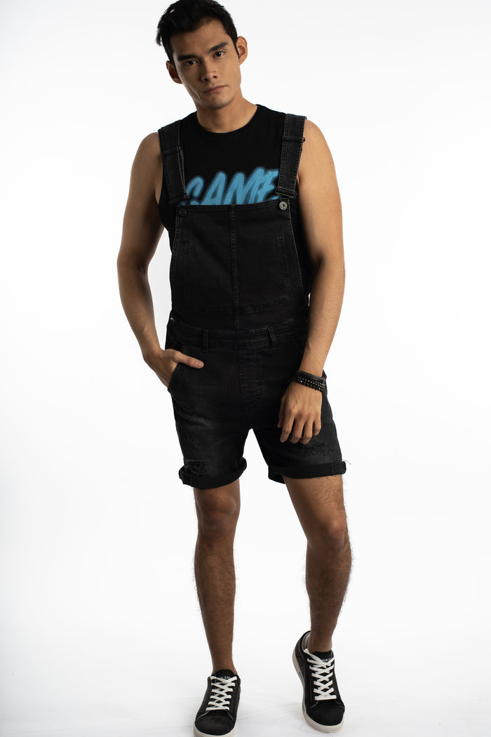 Man in Wayne Black Denim Overalls shorts with utility pockets, cuffed hem, and streetwear fit on a white background.